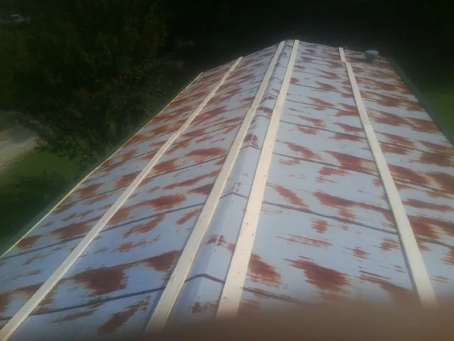Rusted metal roof panels with new wood purlins before replacement — Storm Damage Roof Repair in Blissfield by Roofing Brothers