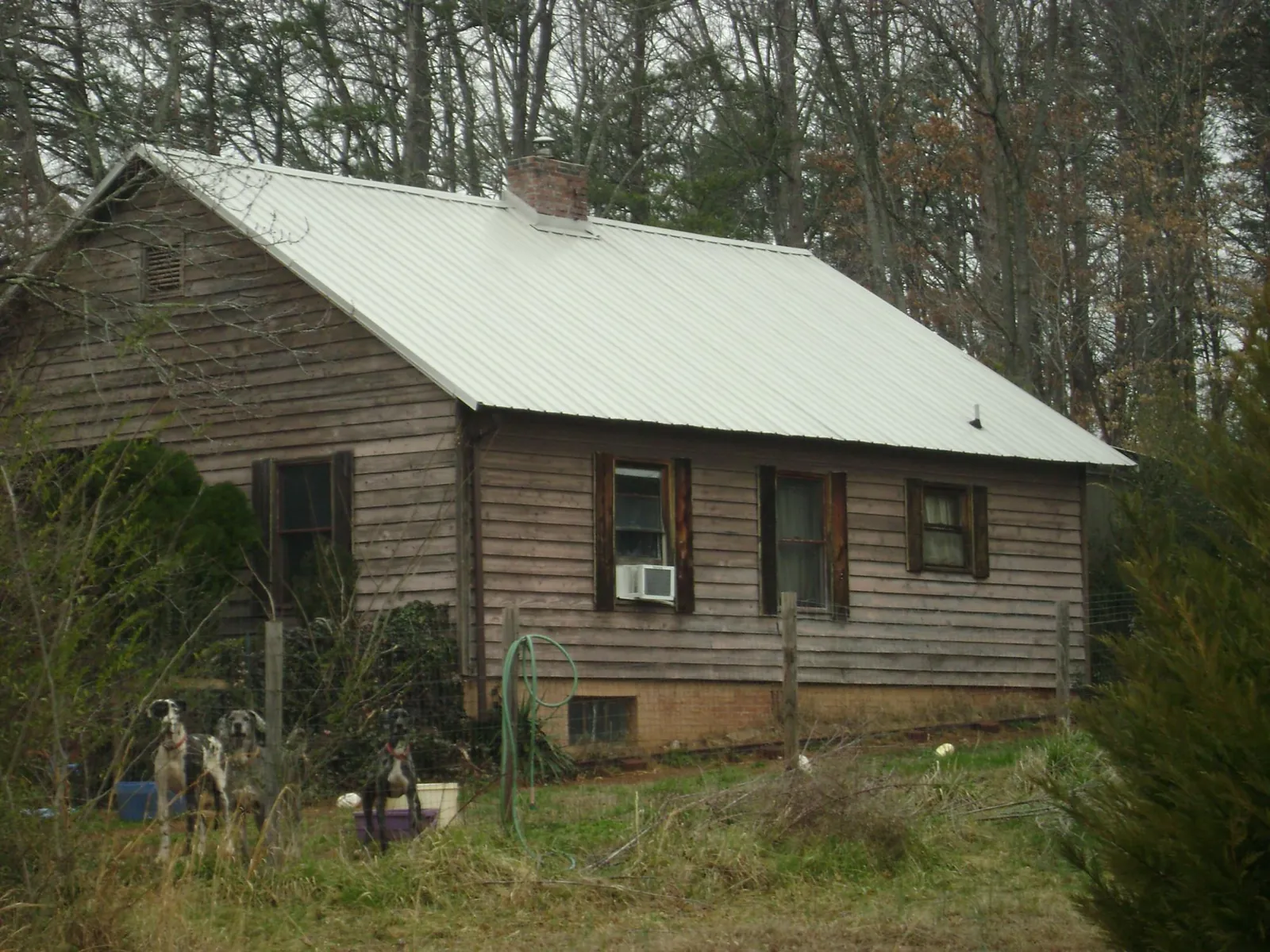 White metal roof on an old wood sided farmhouse, from a Metal Roof Installation job in Blissfield